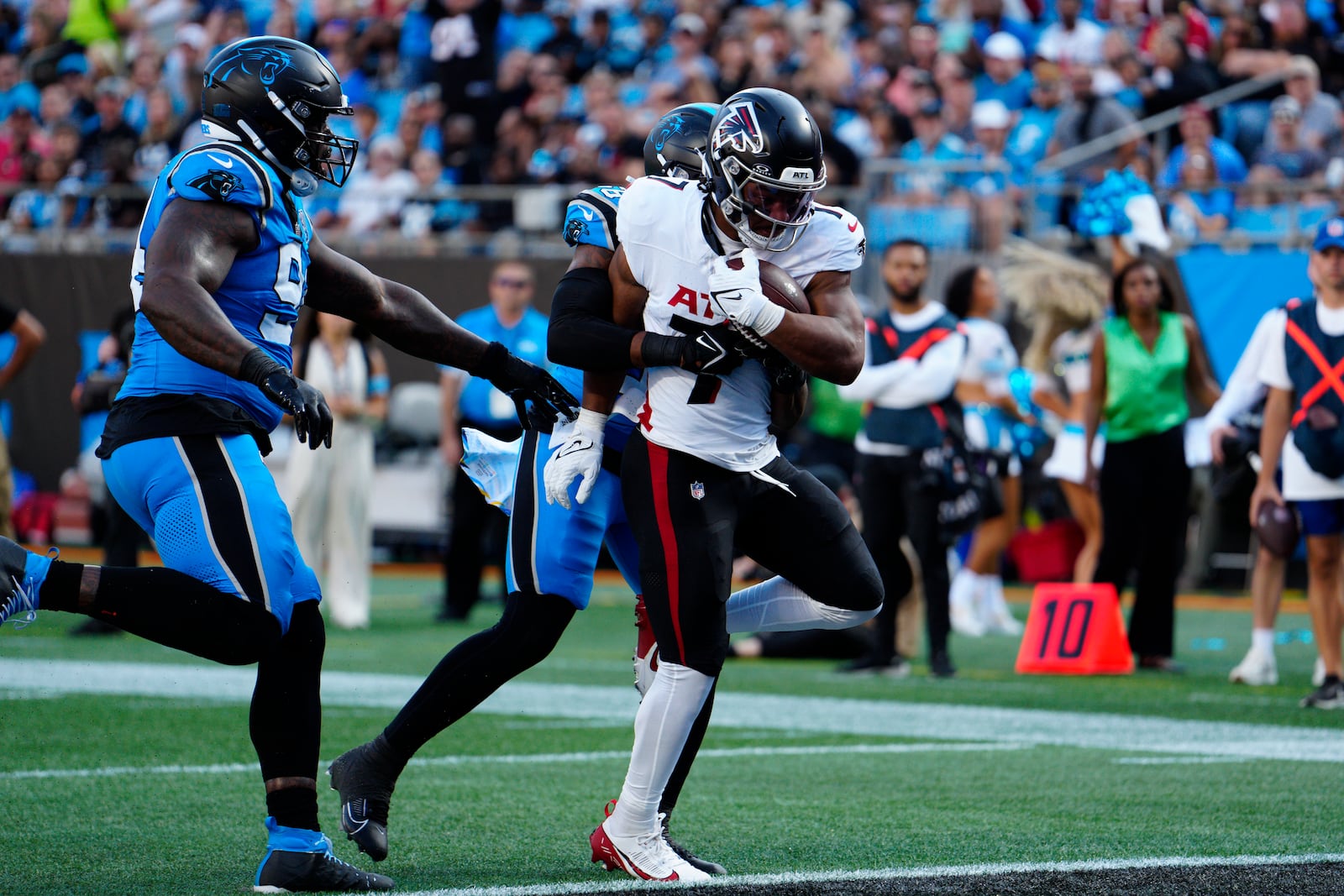 Atlanta Falcons running back Bijan Robinson (7) runs in a touchdown against Carolina Panthers linebacker Trevin Wallace (56) in the first half of an NFL football game against in Charlotte, N.C., Sunday, Oct. 13, 2024. (AP Photo/Jacob Kupferman)