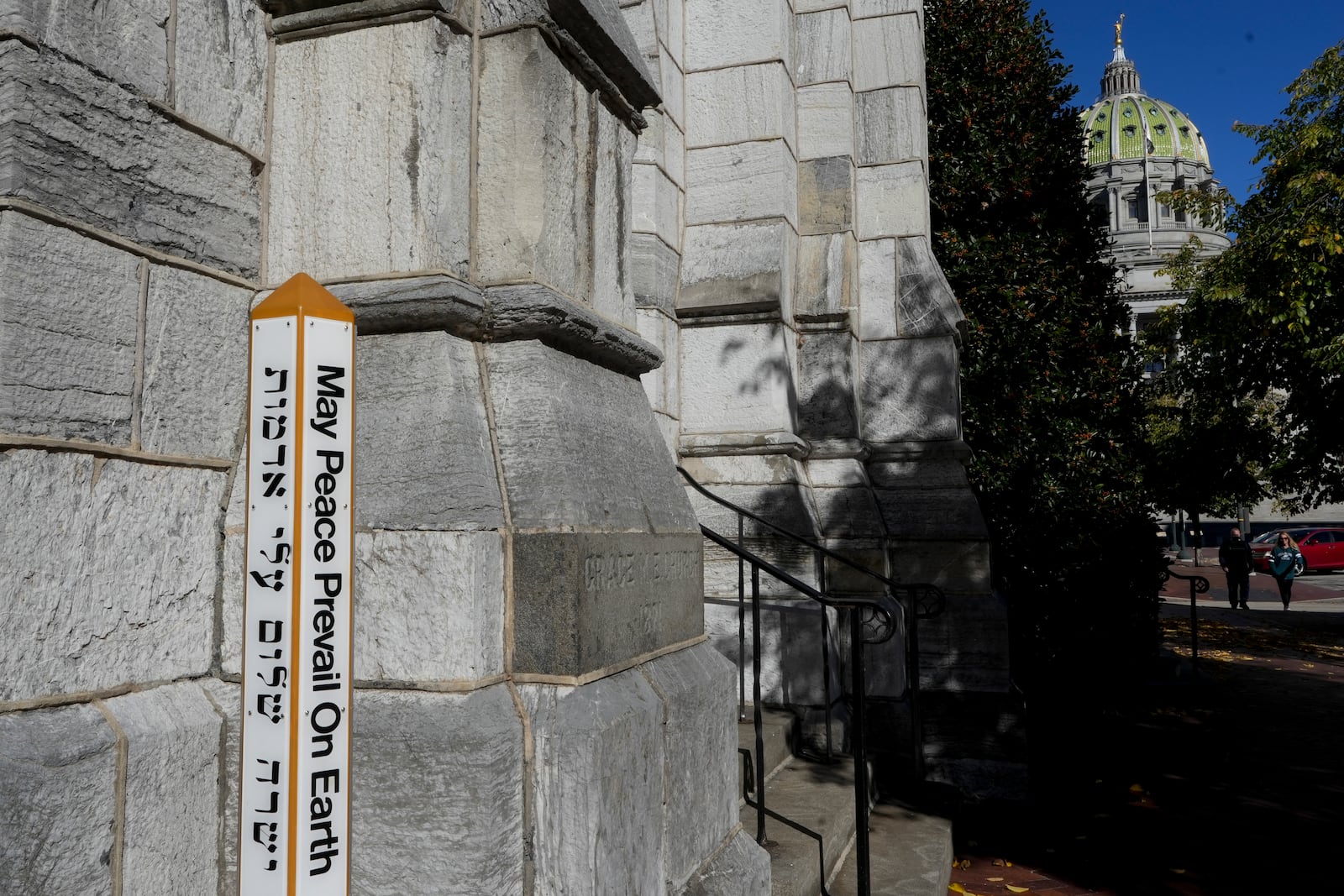 A "Peace Pole" recently installed in front of Grace United Methodist Church near the Pennsylvania Capitol building in Harrisburg, Pa., on Sunday, Oct. 27, 2024. (AP Photo/Luis Andres Henao)