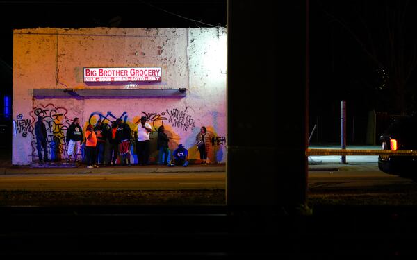 Bystanders look onto the crash scene outside the Big Brother grocery store at Lee Street on Sunday morning.