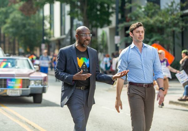 U.S. Sens. Raphael Warnock, left, and Jon Ossoff are holding a joint rally today in Savannah. They are pictured participating in the Pride Parade in Atlanta on Oct.9, 2022.  (Jenni Girtman for The Atlanta Journal-Constitution)