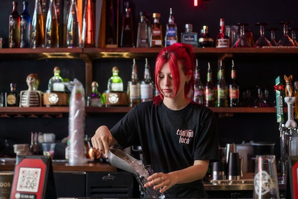 Server Sophie Davis prepares drinks for her customers at Cantina Loca in Alpharetta, one of the restaurants owned by the Will Restaurants Investment Group. The owner, Brian Will, has raised wages to attract and retain workers. (Alyssa Pointer / Alyssa.Pointer@ajc.com)