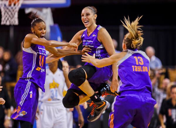 FILE - Phoenix Mercury's DeWanna Bonner (24) celebrating with Diana Taurasi and Penny Taylor (13) as the team wins the WNBA championship with an 87-82 win over the Chicago Sky in Game 3 of the WNBA Finals basketball series, Friday, Sept. 12, 2014, in Chicago. (AP Photo/Kamil Krzaczynski, File)