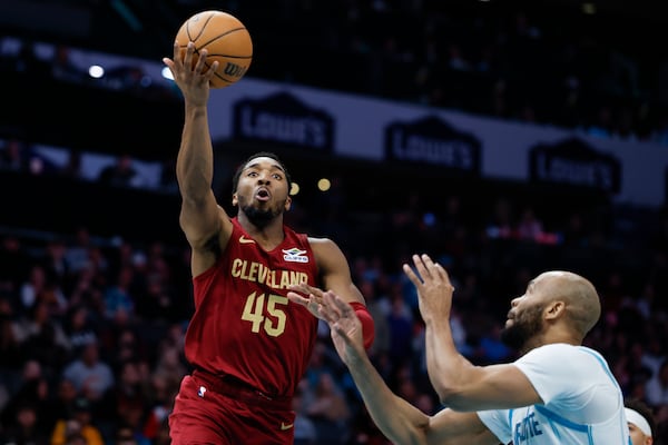 Cleveland Cavaliers guard Donovan Mitchell (45) drives to the basket against Charlotte Hornets forward Taj Gibson, right, during the first half of an NBA basketball game in Charlotte, N.C., Friday, March 7, 2025. (AP Photo/Nell Redmond)