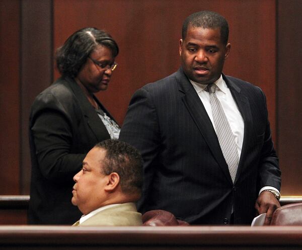 Atlanta City Council President Ceasar C. Mitchell (right) and council members Felicia A Moore (left) and Michael Julian Bond (seated) depart from a special session to discuss airport concessions in the Council Chambers at City Hall to go into executive session on Monday, April 30, 2012.