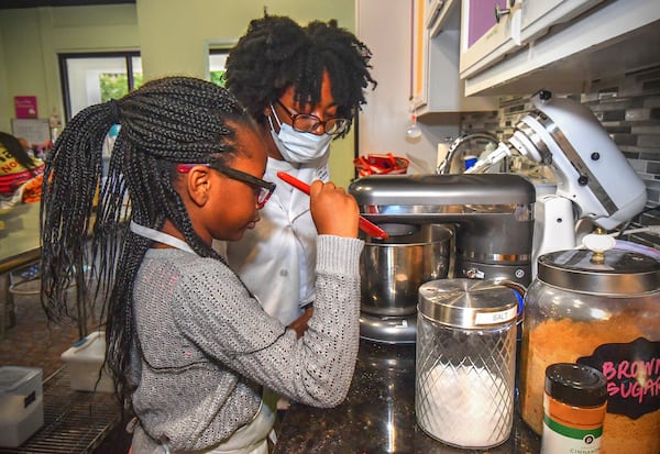 Student Toni Tomori, 7, of Nigeria receives lessons in creating whipped cream plus the safe use of a high-speed blender from Young Chefs Academy instructor Deeyona Massay during a recent class. CONTRIBUTED BY CHRIS HUNT PHOTOGRAPHY