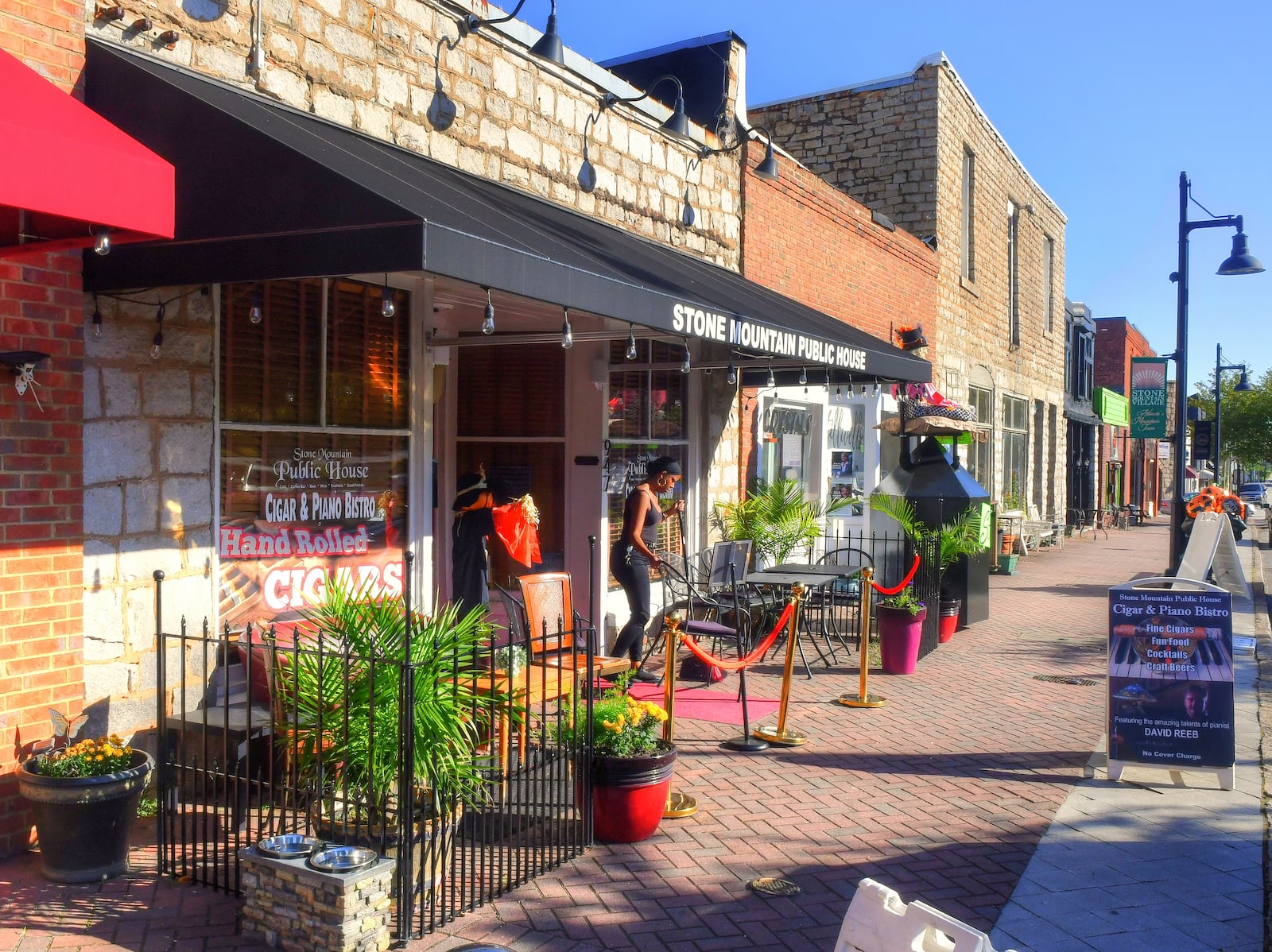 A shopkeeper sets out chairs for patrons at Stone Mountain Public House along Main Street in Stone Mountain Village. (Chris Hunt for The Atlanta Journal-Constitution)