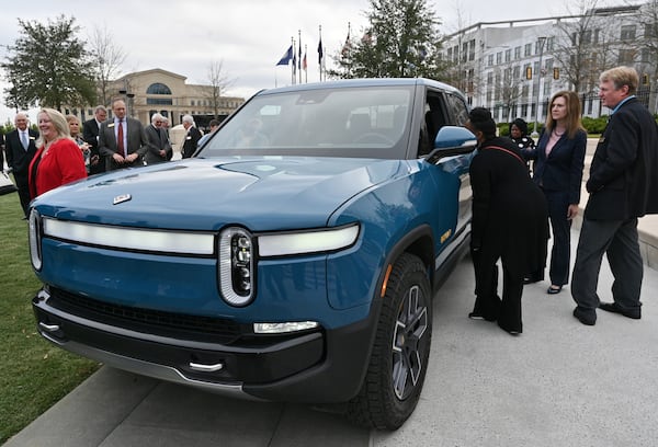 Guests look at a Rivian R1T electric truck during a news conference at Liberty Plaza across from the Georgia State Capitol in Atlanta on Thursday, December 16, 2021. (Hyosub Shin / Hyosub.Shin@ajc.com)