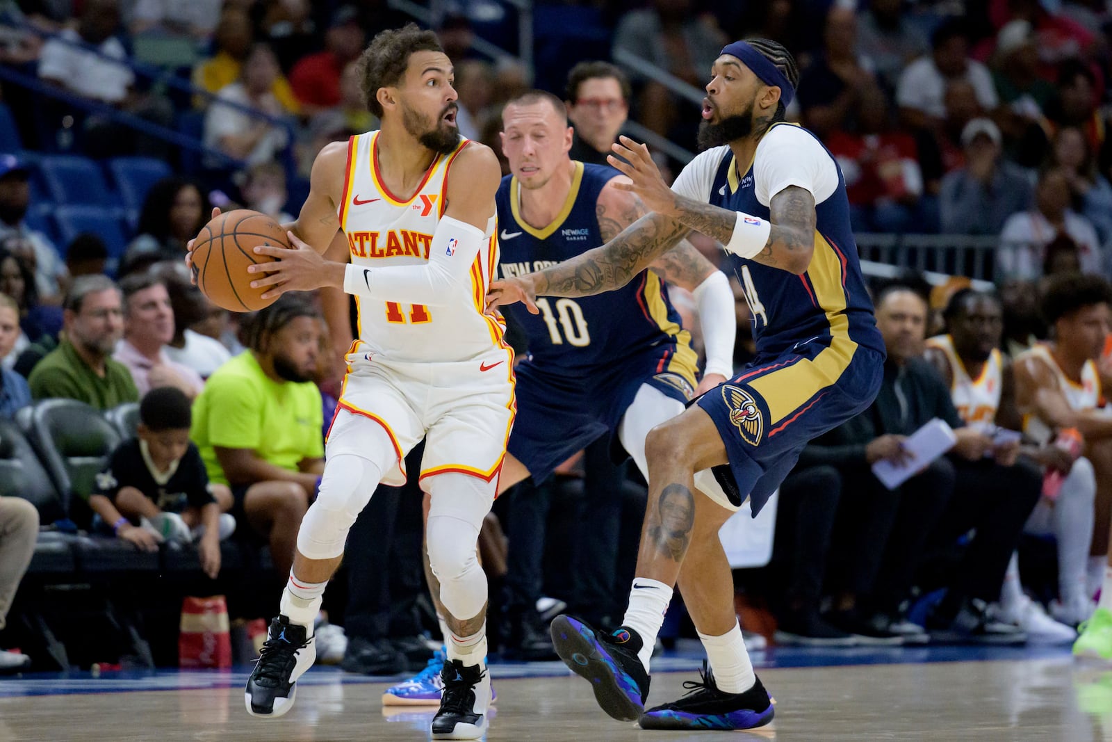 Atlanta Hawks guard Trae Young, left, looks to pass the ball around New Orleans Pelicans forward Brandon Ingram, right, during the first half of an NBA basketball game in New Orleans, Sunday, Nov. 3, 2024. (AP Photo/Matthew Hinton)