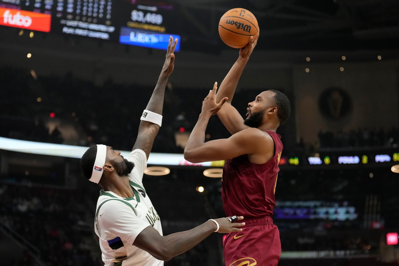 Cleveland Cavaliers forward Evan Mobley, right, shoots over Milwaukee Bucks forward Bobby Portis Jr., left, in the first half of an NBA basketball game, Monday, Nov. 4, 2024, in Cleveland. (AP Photo/Sue Ogrocki)