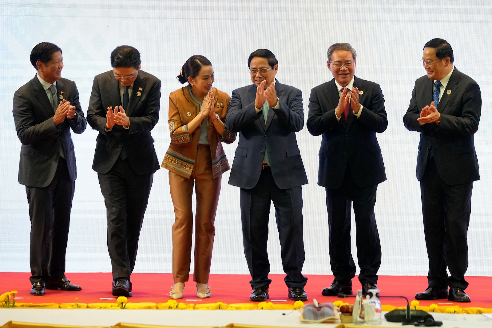 From left, Philippine's President Ferdinand Marcos Jr., Singapore's Prime Minister Lawrence Wong, Thailand's Prime Minister Paetongtarn Shinawatra, Vietnam's Prime Minister Pham Minh Chinh, Chinese Premier Li Qiang and Laos' Prime Minister Sonexay Siphandone applaud after a group photo session during the 27th Association of Southeast Asian Nations (ASEAN)-China Summit in Vientiane, Laos, Thursday, Oct. 10, 2024. (AP Photo/Dita Alangkara)