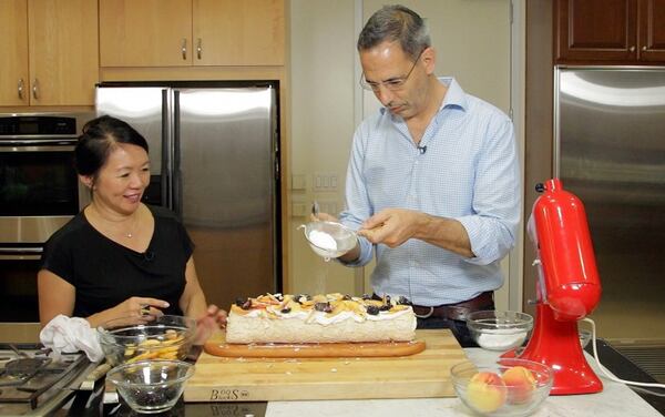 Yotam Ottolenghi and Helen Goh assemble a fruit pavlova, one of the many dessert recipes from their new book, "Sweet."  (Myung J. Chun / Los Angeles Times/TNS)