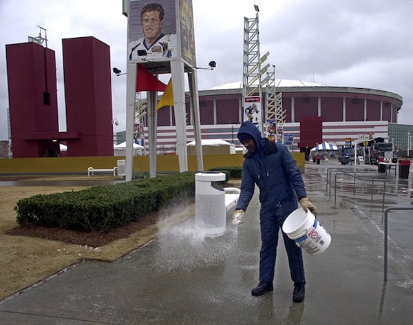 James Calloway throws salt on the walkway in front the Georgia Dome Saturday, Jan. 29, 2000, after an ice and rain storm coated the city just one day before Super Bowl XXXIV between the St. Louis Rams will be meeting the Tennessee Titans.