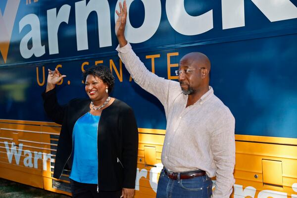 Democratic gubernatorial nominee Stacey Abrams and Democratic U.S. Sen. Raphael Warnock greet supporters during a campaign stop at the Cobb County Civic Center on Wednesday, Aug. 31, 2022, in Marietta, Georgia. (Jason Getz/The Atlanta Journal-Constitution/TNS)