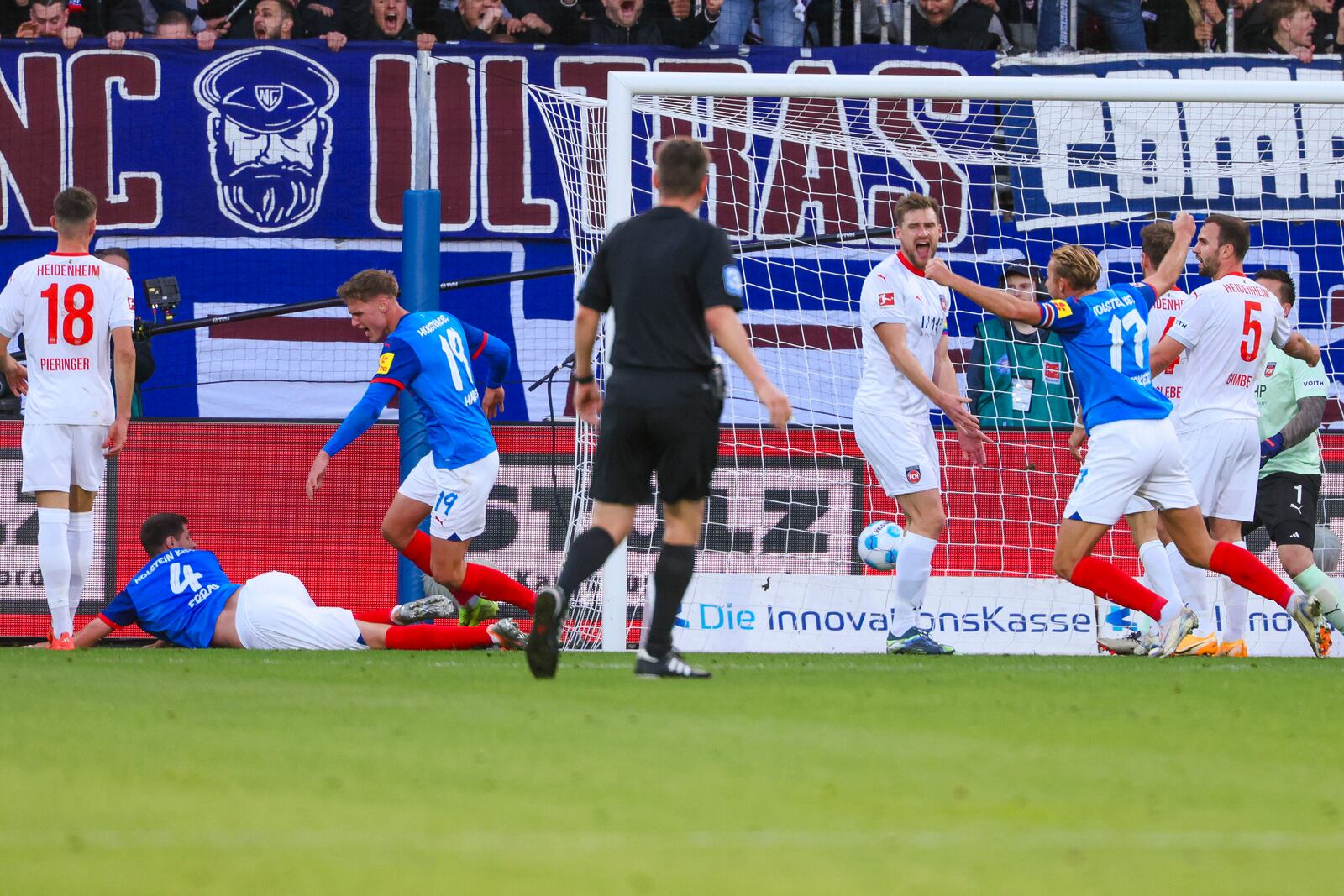 Kiel's Patrick Erras, left, scores his team's first goal during the Bundesliga soccer match between Holstein Kiel and FC Heidenheim at the Holstein Stadium in Kiel, Germany, Saturday, Nov. 2, 2024. (Frank Molter/dpa via AP)