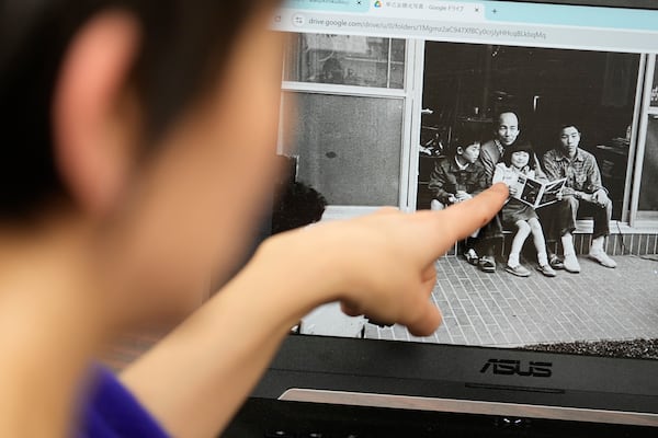 Ai Saotome, a video archivist, points a newly digitized old photo of her father, Katsumoto Saotome with his family, at the Center of the Tokyo Raids and War Damage on Feb. 24, 2025, in Tokyo. (AP Photo/Eugene Hoshiko)