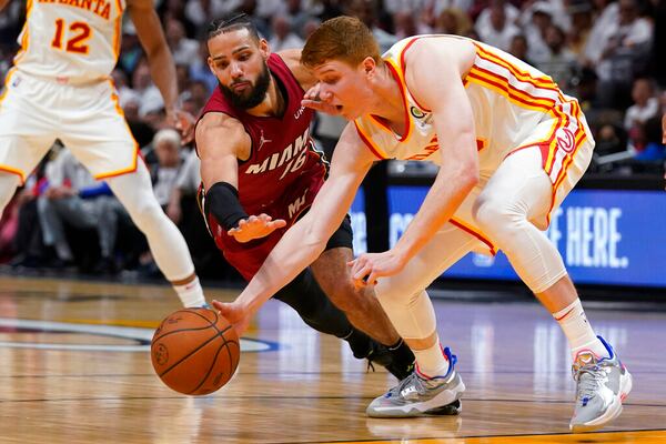 Miami Heat forward Caleb Martin (16) and Atlanta Hawks guard Kevin Huerter scramble for a loose ball during the second half of Game 5 of an NBA basketball first-round playoff series, Tuesday, April 26, 2022, in Miami. (AP Photo/Wilfredo Lee)