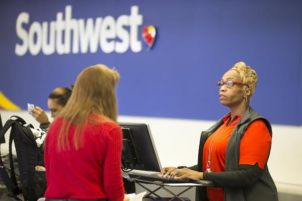 03/13/2019 — Atlanta, Georgia — A Southwest Airlines desk agent assists a customer at Hartsfield-Jackson Atlanta International Airport in Atlanta, Wednesday, March 13, 2019. On Wednesday, President Trump grounded all Boeing 737 Max 8 and Max 9 planes in the United States. Airlines that used these Boeing planes are American Airlines, Southwest Airlines and United Airlines. (ALYSSA POINTER/ALYSSA.POINTER@AJC.COM)