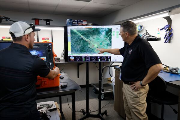 Jeff Holland UAS Strategic Development with Phoenix Air Unmanned show the drone's path during a power line inspection simulation as Brett Goodsite, a Lead Pilot Instructor, controls the drone. Miguel Martinez / miguel.martinezjimenez@ajc.com 