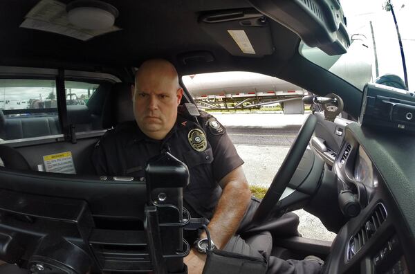 September 9, 2014 — Cpl. John Lowe of the Doraville Police Department writes a speeding ticket for a driver he clocked at 51 mph in a 35 mph zone. The city of Doraville generates some of the highest revenues from traffic tickets of any jurisdiction in metro Atlanta. BOB ANDRES / BANDRES@AJC.COM