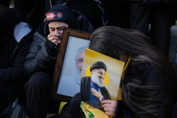 Mourners hold pictures of Hezbollah's former leader Hassan Nasrallah, right, and his cousin and successor Hashem Safieddine as they gather to attend their funeral procession in Beirut, Lebanon, Sunday Feb. 23, 2025. (AP Photo/Bilal Hussein)