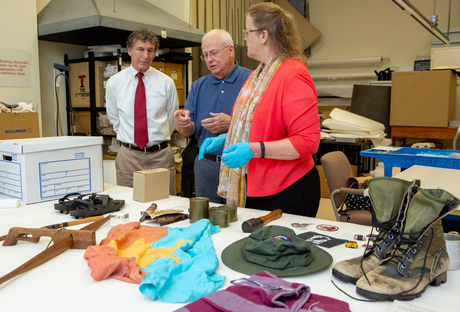 Joe Bruckner (from left), Tony Hilliard and Sue VerHoef look over artifacts from a Vietnam War exhibit held earlier this year at the Atlanta History Center. (Photo by Phil Skinner)