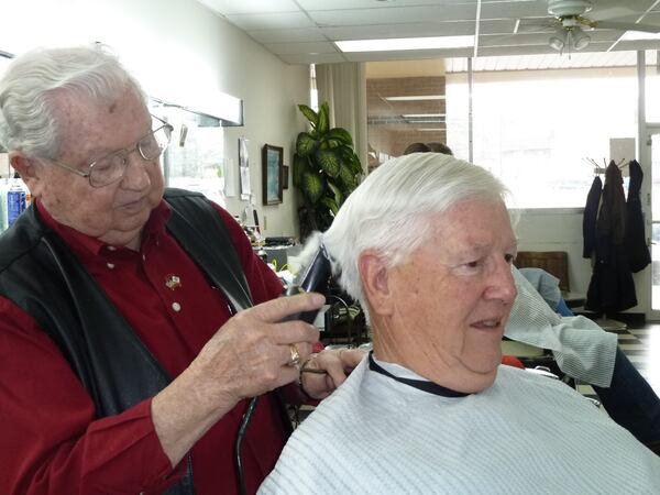 Joe Burges gives a haircut to Tom Marchbanks, who was a loyal customer for decades.