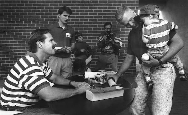 Former major league baseball player, and current Columbus city councilor Glenn Davis, seated left, signs autographs at Golden Park in Columbus, Georgia. (Courtesy of Mike Haskey)