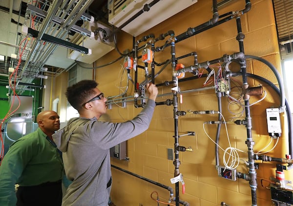 Building automation instructor Robert Croom looks on while student Jomaris Soseph works on a hydronic wall during his class in the Building Automation Systems program at Georgia Piedmont Technical College on Thursday, Jan. 30, 2020, in Clarkston. CURTIS COMPTON / CCOMPTON@AJC.COM