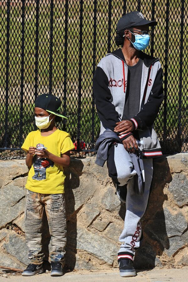 Henry Richmond (right) and Messiah Richmond wait in line during the Grab and Go free food and groceries event on Friday, April 17, 2020, at Allen Hills Apartments in Atlanta. The community effort to help families during the COVID-19 pandemic was led by the Fulton County district attorney’s office. (Christina Matacotta, for The Atlanta Journal-Constitution)