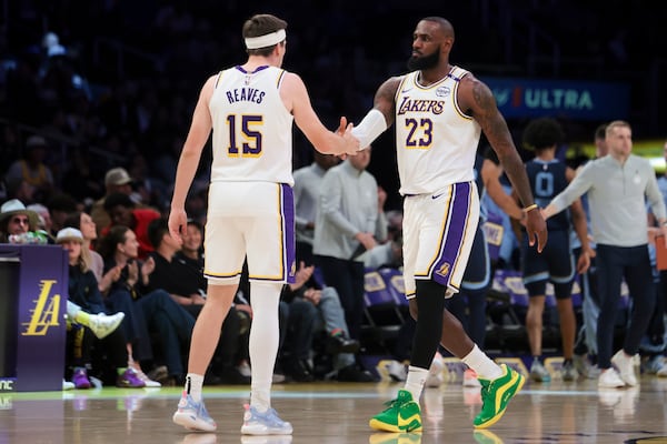 Los Angeles Lakers forward LeBron James (23) celebrates with guard Austin Reaves (15) during the first half of an NBA basketball game against the Memphis Grizzlies, Sunday, Dec. 15, 2024, in Los Angeles. (AP Photo/Jessie Alcheh)