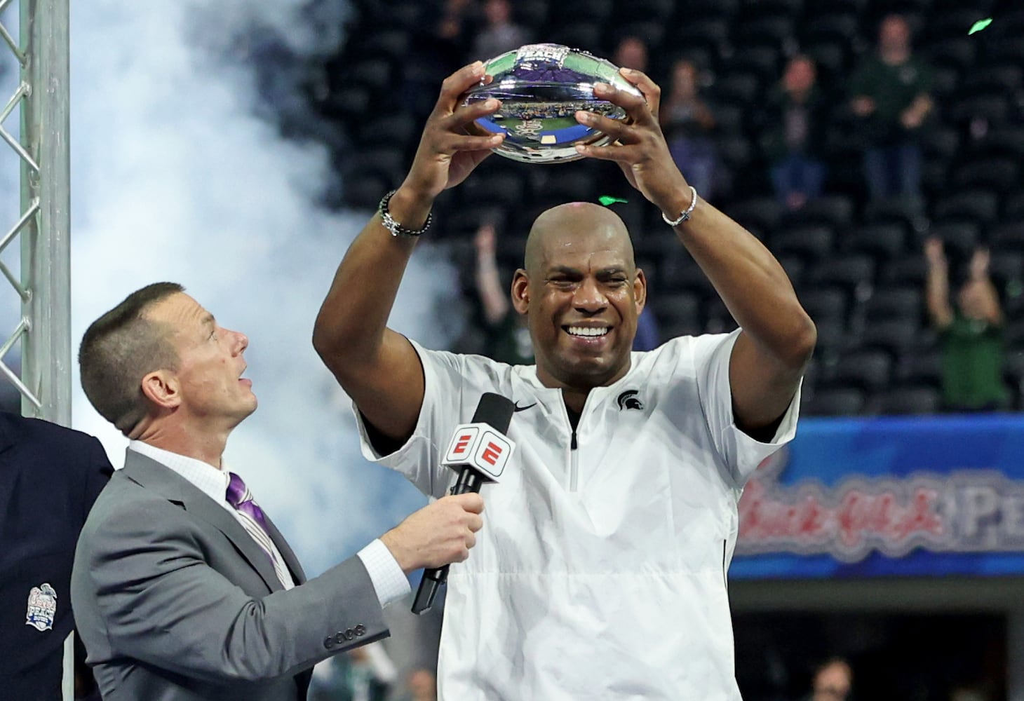 Michigan State Spartans head coach Mel Tucker hoists the trophy after their 31-21 win against the Pittsburgh Panthers during the Chick-fil-A Peach Bowl at Mercedes-Benz Stadium in Atlanta, Thursday, December 30, 2021. Tucker is a former defensive coordinator at the University of Georgia. JASON GETZ FOR THE ATLANTA JOURNAL-CONSTITUTION