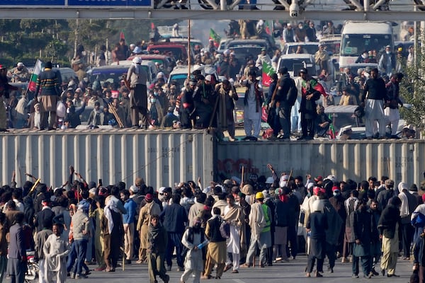 Supporters of imprisoned former premier Imran Khan's Pakistan Tehreek-e-Insaf party, remove shipping container to clear way for their rally demanding Khan's release, in Islamabad, Pakistan, Tuesday, Nov. 26, 2024. (AP Photo/Anjum Naveed)