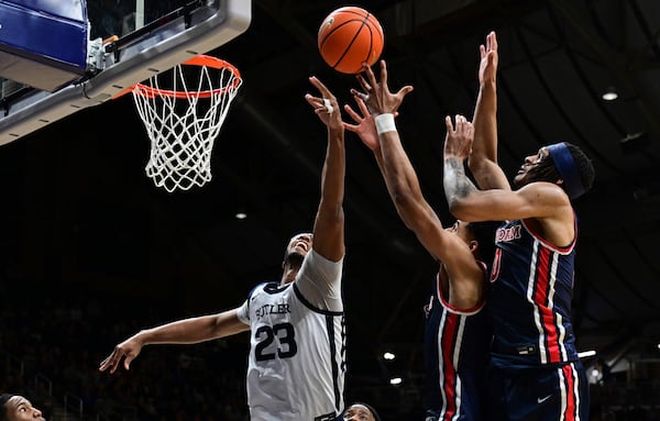 Butler center Andre Screen (23) jumps up for a rebound in front of St. John's guard RJ Luis Jr. and guard Aaron Scott during the first half of an NCAA college basketball game, Wednesday, Feb. 26, 2025, in Indianapolis, Ind. (AP Photo/Marc Lebryk)