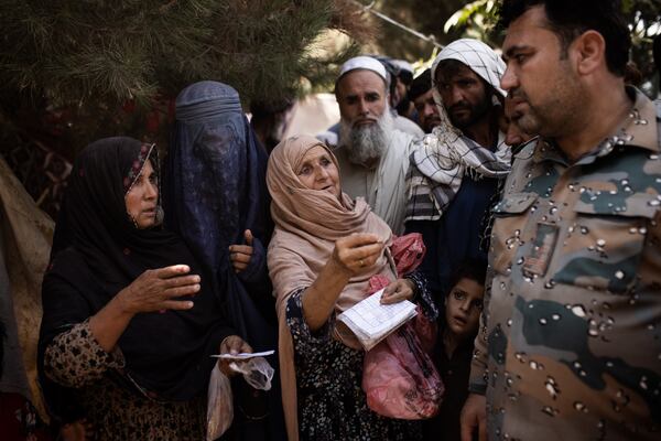 FILE - Displaced Afghan women plead for help with a police officer at the Bibi Amina school in Kunduz, Afghanistan, July 7, 2021. Women would be most at risk under Taliban rule. When the group controlled Afghanistan from 1996 to 2001, it barred women from taking most jobs or receiving educations and practically made them prisoners in their own homes — though this was already custom for many women in rural parts of the country. (Jim Huylebroek/The New York Times)