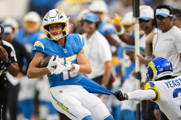 Los Angeles Chargers wide receiver Ladd McConkey runs with the ball as Los Angeles Rams safety Russ Yeast pulls his jersey during an NFL preseason football game, Saturday, Aug. 17, 2024, in Inglewood, Calif. (AP Photo/Kyusung Gong)