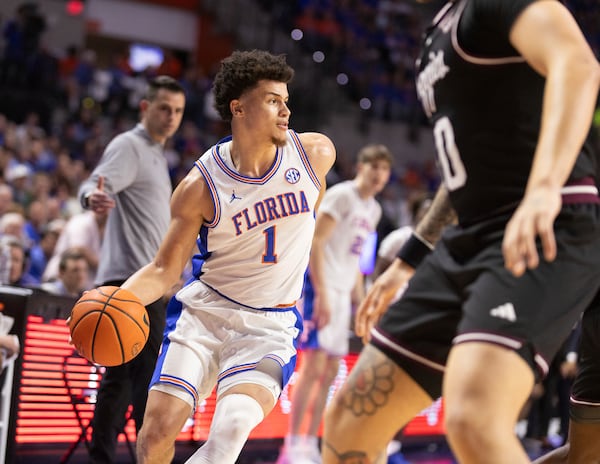 Florida guard Walter Clayton Jr. (1) drives against Texas A&M guard Jace Carter (0) during the second half of an NCAA college basketball game, Saturday, March 1, 2025, in Gainesville, Fla. (AP Photo/Alan Youngblood)