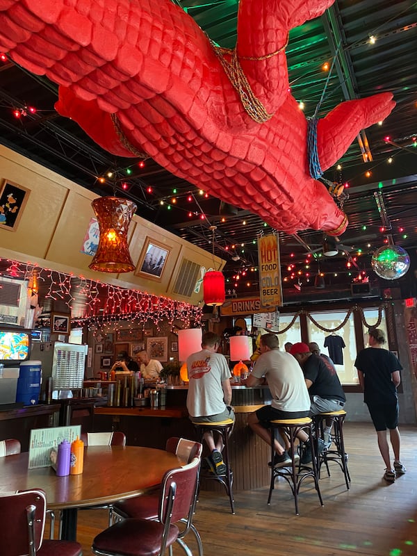 A 20-foot red alligator dangling from the ceiling contributes to the eclectic decor at Gene's. (Ligaya Figueras/lfigueras@ajc.com)