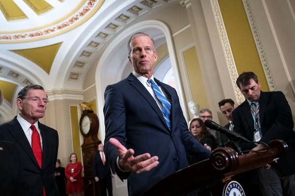 Senate Majority Leader Sen. John Thune, R-S.D., center, accompanied by Sen. John Barrasso, R-Wyo., left, speaks to reporters after a Senate policy luncheon, at the Capitol in Washington, Tuesday, Feb. 25, 2025. (AP Photo/Ben Curtis)