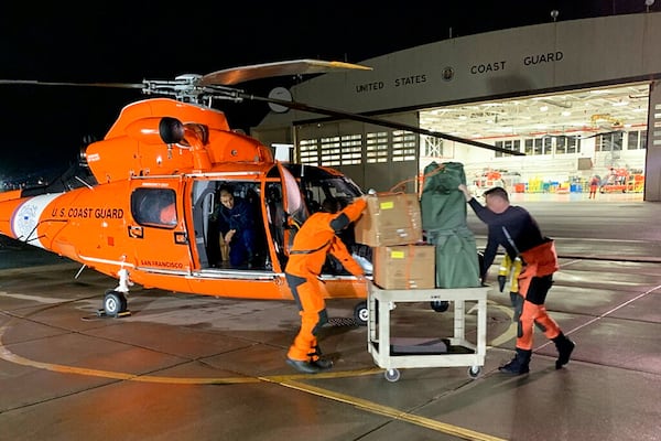 In this Friday, March 6, 2020, image provided by the U.S. Coast Guard, air station crew members load personal protective equipment into a helicopter in San Francisco. Thousands of anxious people were confined Saturday to a cruise ship circling in international waters off the San Francisco Bay Area, after 21 passengers and crew members tested positive for the new coronavirus. The Grand Princess was forbidden to dock in San Francisco. (Photo: Petty Officer 3rd Class Taylor Bacon/U.S. Coast Guard District 11 via AP)