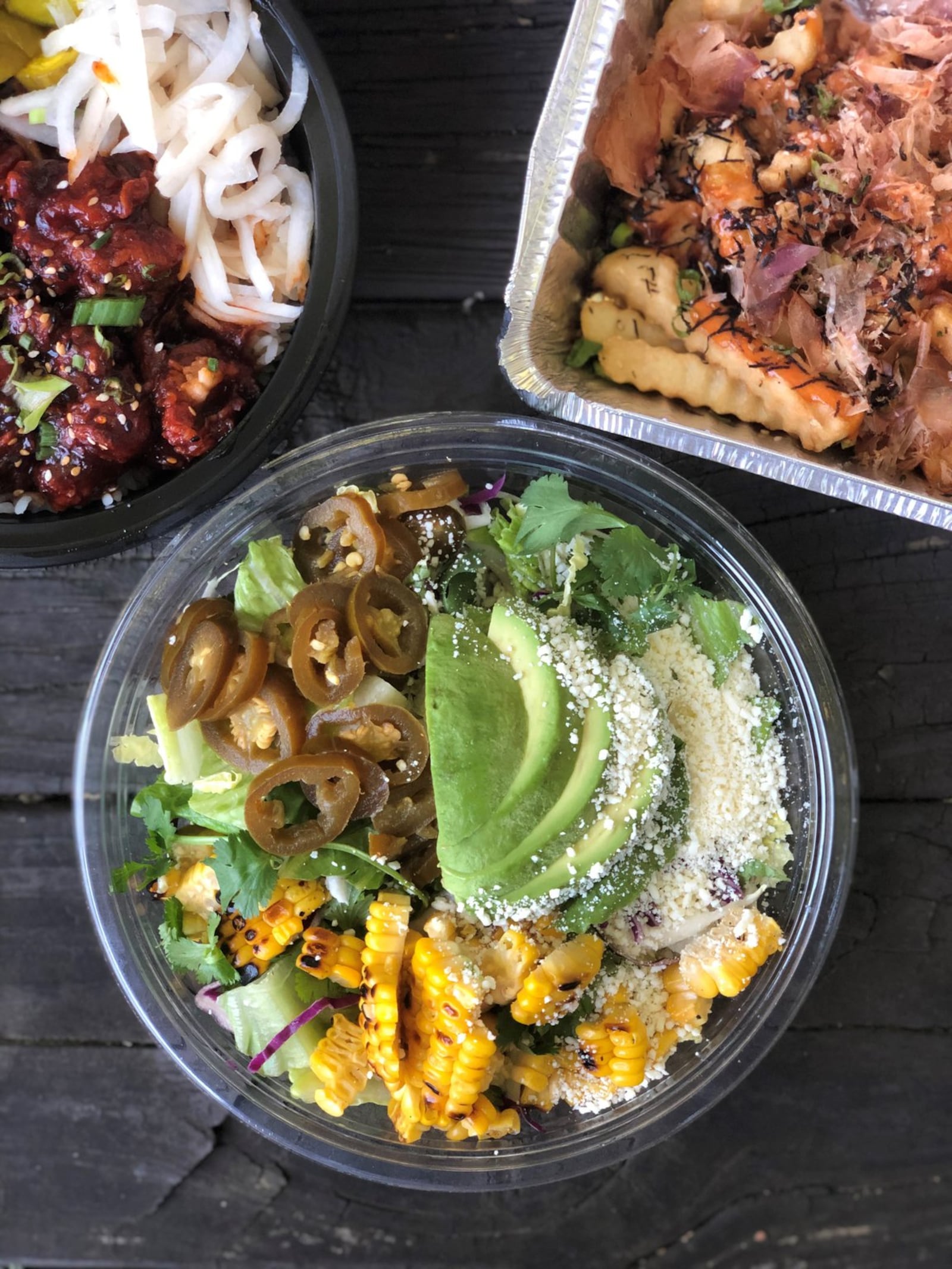 Flanking Whiskey Bird’s Little Bird Caesar are the Korean fried chicken bowl (left) and the okonomiyaki fries. CONTRIBUTED BY WENDELL BROCK