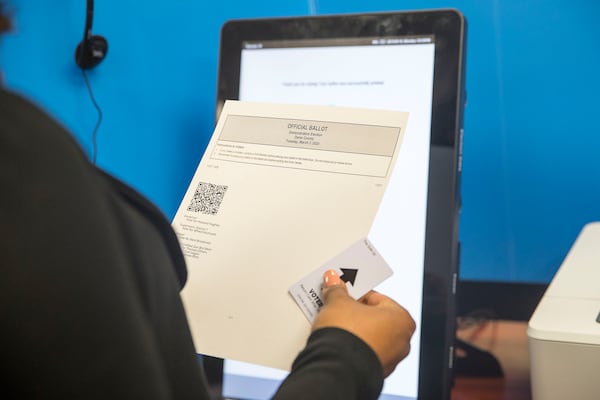 09/16/2019 -- Atlanta, Georgia -- Breanna Thomas, Election liaison for the Georgia Secretary of State, looks over her ballot after using the new Georgia voting machine at the James H. "Sloppy" Floyd building in Atlanta, Monday, September 16, 2019. Next to the touchscreen, an HP printer creates a paper ballot. The ballot includes a text listing of voters' choices along with a bar code that can be read by an optical scanning machine. Voters can review their choices for accuracy and request a new ballot if needed. (Alyssa Pointer/alyssa.pointer@ajc.com)