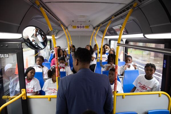 Atlanta Mayor Andre Dickens greets a group of third graders packed onto a MARTA bus before the group heads out to read their favorite books while driving around Atlanta on Feb. 2, 2023. (Riley Bunch/riley.bunch@ajc.com)