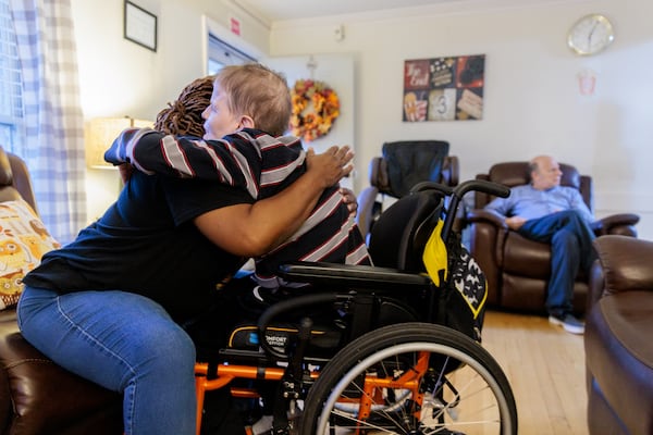 This 2022 file photo shows Jeffrey Clarke, a resident in a Tucker group home for people with disabilities, hugging a caregiver.