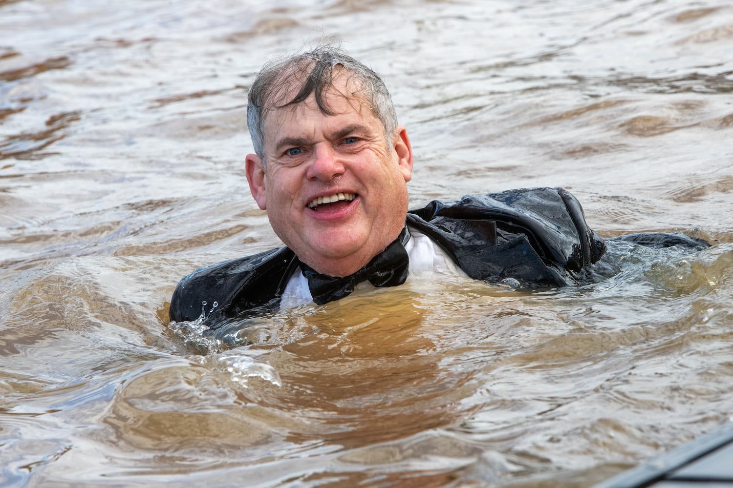 Long-time plunger, Tom Diaz lost his penguin mask and top hat in his quick swim at the 26th annual Polar Bear Paddle and Plunge at Lake Lanier Olympic Park on Monday, Jan 1, 2024.  There is a category of best costume in the event, as well as best splash and fastest exit from the lake. (Jenni Girtman for The Atlanta Journal-Constitution)