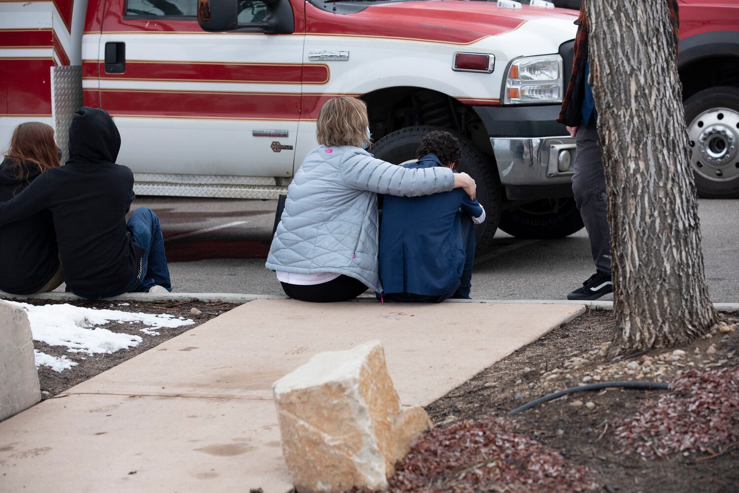 People comfort each other outside of the Boulder King Soopers grocery store after a shooting that killed multiple people in Boulder, Colo., on Monday, March 22, 2021. (Eliza Earle/The New York Times)