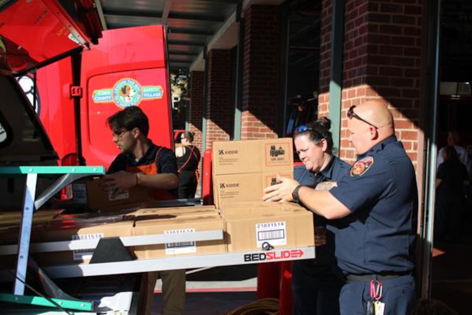 Members of the Forsyth County Fire Department load a car with alarms during Kidde's Cause For Alarm donation event at the Marietta Fire Museum. (Photo Courtesy of Isabelle Manders)