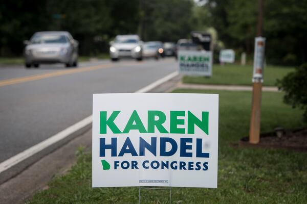 Vikki Thomas's campaign sign for Karen Handel is shown in her yard along with signs belong to her neighbors, Friday, June 2, 2017, in Roswell, Ga. Signs have been stolen in the area, but so far, these have survived. (John Amis)