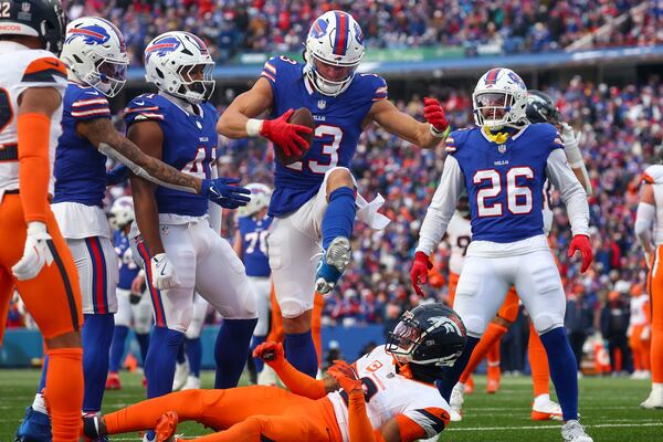 Buffalo Bills wide receiver Mack Hollins (13) steps over Denver Broncos cornerback Pat Surtain II (2) after making a catch during the fourth quarter of an NFL wild card playoff football game, Sunday, Jan. 12, 2025, in Orchard Park, N.Y. Hollins was called for a personal foul. (AP Photo/Jeffrey T. Barnes)