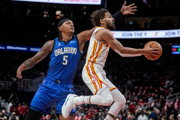 Atlanta Hawks guard Trae Young (11) gets by Orlando Magic forward Paolo Banchero (5) during the first half of an NBA basketball game, Thursday, Feb. 20, 2025, in Atlanta. (AP Photo/Mike Stewart)