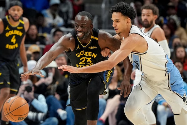 Golden State Warriors forward Draymond Green (23) and Atlanta Hawks forward Zaccharie Risacher (10) vie for a loose ball during the first half of an NBA basketball game, Saturday, March 22, 2025, in Atlanta. (AP Photo/Mike Stewart)